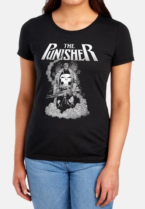 Frau trägt ein schwarzes T-Shirt mit dem Text "The Punisher" und einer Grafik einer Figur, die ein Gewehr hält, mit Rauch um die Füße.