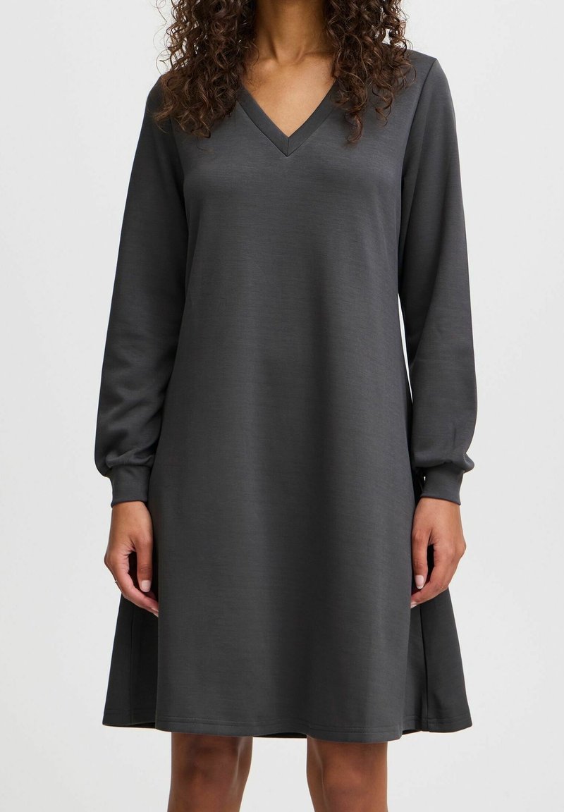 Grå långärmad klänning med V-ringning, avslappnad passform och mjuk textur. Fallande precis ovanför knäet med elastiska ärmslut.