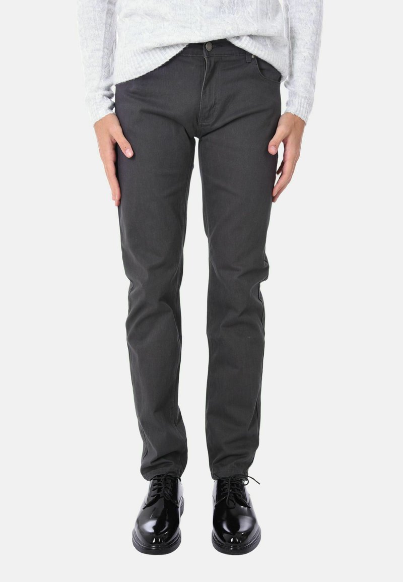 Pantaloni di cotone grigio scuro con un design a gamba dritta, abbinati a scarpe nere lucide. Il tessuto ha una superficie liscia senza motivi visibili.