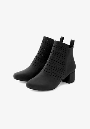Botines negros de piel sintética, con patrones triangulares recortados, un tacón ancho y tiradores en la parte posterior para facilitar el calzado.