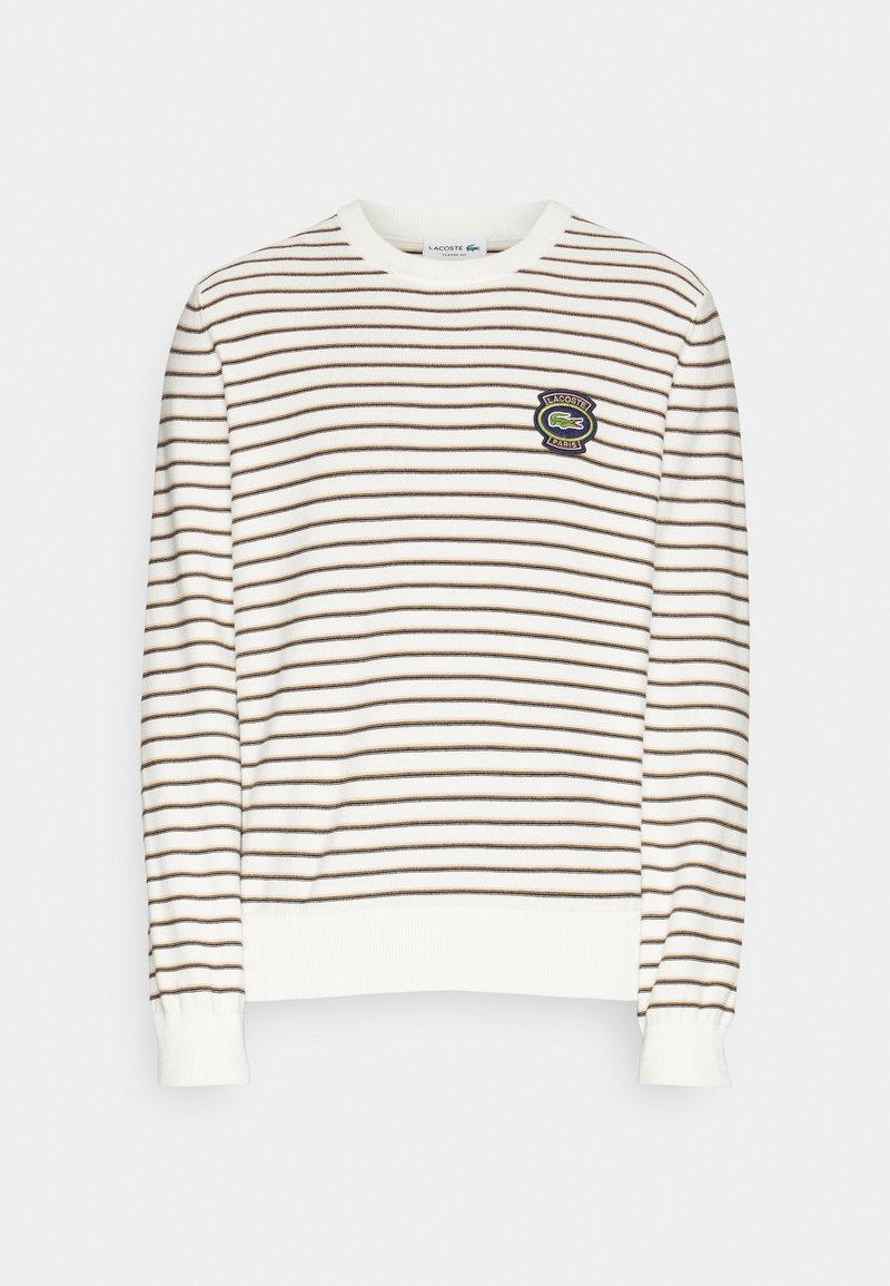 Gestreepte trui in crème met bruine horizontale lijnen. Heeft een ronde halslijn en een textuur in de boorden. Inclusief een geborduurd logodetail.