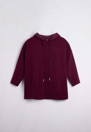 Sudadera con capucha burdeos de manga larga, con detalles de cordón y una textura suave. Diseño ligeramente oversize con un dobladillo redondeado.