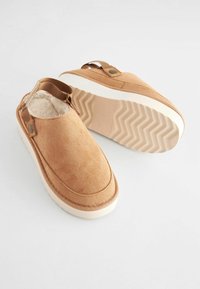 Zsákmány színű nubukbőr slip-on cipők bolyhos belsővel, elasztikus oldalsó díszítésekkel és fehér gumitalppal, amely zig-zag mintás.