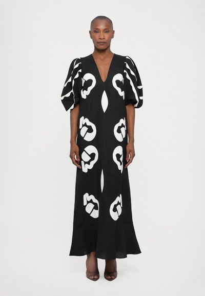 Robe maxi noire avec des motifs abstraits blancs, décolleté en V profond et manches bouffantes volumineuses. Tissu lisse avec un ourlet évasé.