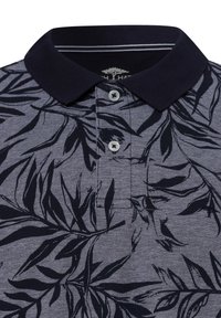 Polo shirt in marineblauw met een subtiel bladdessin. Voorzien van een contrasterende kraag en drie knopen, gemaakt van gestructureerde stof.