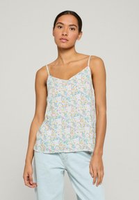 Bloemen camisole in lichtblauw, met een v-hals en dunne verstelbare verstelbare bandjes. De stof heeft een zachte, textuurachtige afwerking met pastel bloemenpatronen.