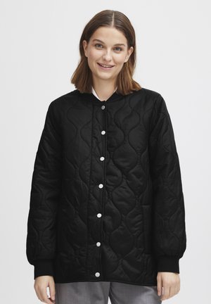 Schwarze gesteppte Jacke mit rundem Ausschnitt, Druckknöpfen und gerippten Bündchen. Verfügt über eine glänzende Oberfläche und glatte Textur.