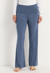 Siniset leveälahkeiset joogahousut, joissa on laaja ja mukava vyötärö. Vaimennettu kangas, jossa on pehmeä rakenne, sopii aktiiviseen pukeutumiseen.