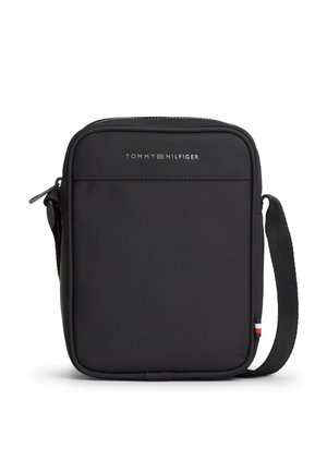 Petit sac bandoulière rectangulaire noir avec logo Tommy Hilfiger, fermeture éclair sur le dessus et bandoulière réglable avec une étiquette rouge, blanche et bleue.