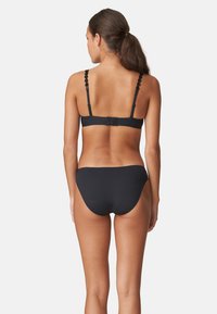 Schwarzes Bikini-Set mit einem gewellten Trägerdesign, weichem Stoff und einem schlichten Schnitt für Oberteil und Unterteil sowie einem sicheren Verschluss auf der Rückseite.