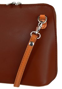 Braune Lederhandtasche mit glänzender Oberfläche, abnehmbarem Tragegurt, silberner Metallbeschläge und kontrastierenden orangen Nähten.
