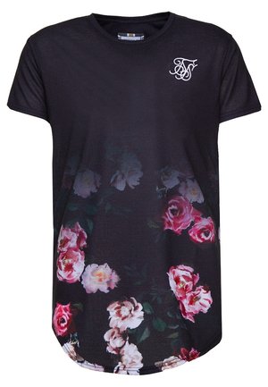 Camisa negra de manga corta con cuello redondo, patrón floral blanco en la parte inferior y logo de iniciales entrelazadas en blanco en la parte superior izquierda del pecho.