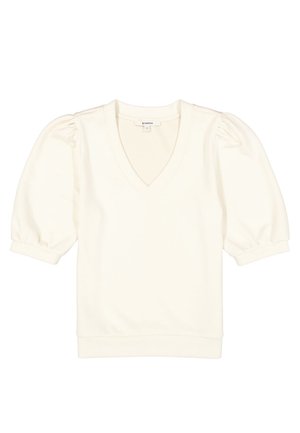 Haut à manches courtes couleur crème avec manches bouffantes, encolure en V, et poignets et ourlet côtelés.