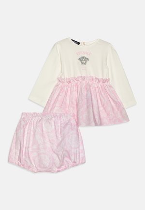 Vestido de bebé de manga larga color crema con falda floral rosa y bloomers a juego con estampado floral rosa, logotipo de Versace en rosa sobre la cabeza de Medusa en el pecho.