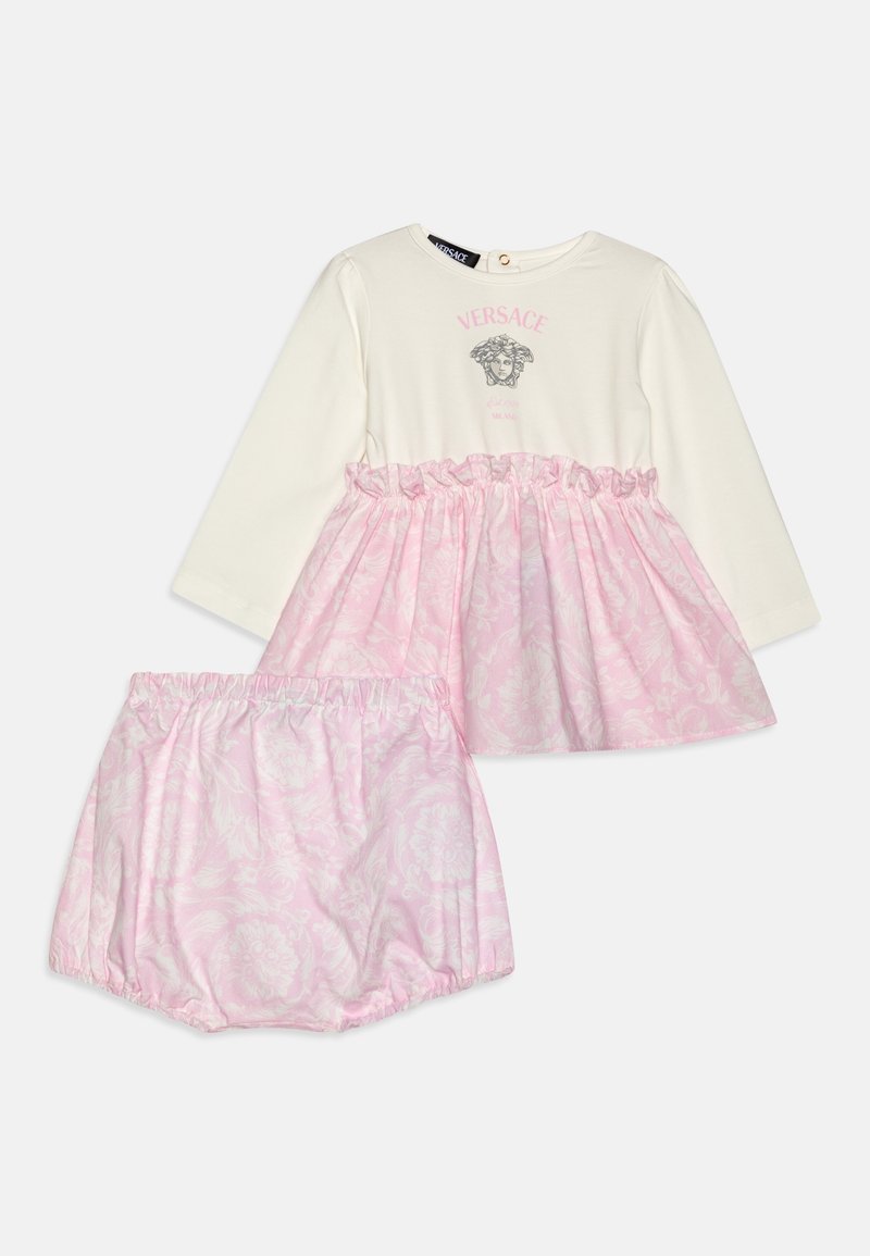 Robe longue manches longues pour bébé couleur crème avec jupe à fleurs roses et bloomer assorti à fleurs roses, logo Versace en rose au-dessus de la tête de Méduse sur la poitrine.