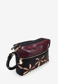 Bolso de cuero para el hombro con un top burdeos y cuerpo negro acolchado, que presenta bordados florales en rojo, crema y detalles en dorado. Cierre de doble cremallera.