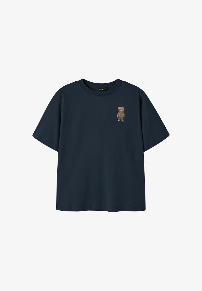 T-shirt bleu marine à manches courtes avec un petit motif d'un ours en peluche portant une veste marron sur la poitrine gauche.
