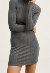 Szara sukienka z golfem, w prążki, z długimi rękawami i dopasowanym fasonem, charakteryzująca się pionowymi paskami i miękką teksturą.