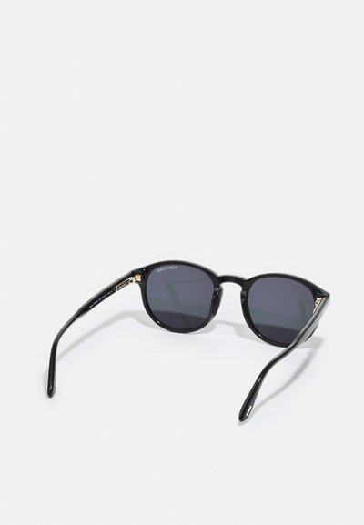 Ochelari de soare negri cu rame rotunde, lentile întunecate și finisaj lucios. Accente de hardware aurie la tâmple. Design clasic cu linii elegante.