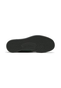 Black rubber outsole with textured tread pattern, featuring a circular logo and subtle branding detail. Green fabric upper visible along the edges.