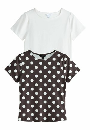 To kortærmede t-shirts med rund hals, den ene ensfarvet hvid og den anden sort med hvide polkaprikker, lagt fladt overlappende på en hvid baggrund.