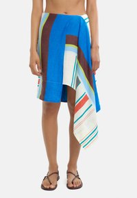 Niebieska, wielokolorowa spódnica z lnu z wyraźnymi paskami w kolorze zielonym, brązowym i czerwonym. Asymetryczny krój z opadającym hemem. Lekka tekstura.