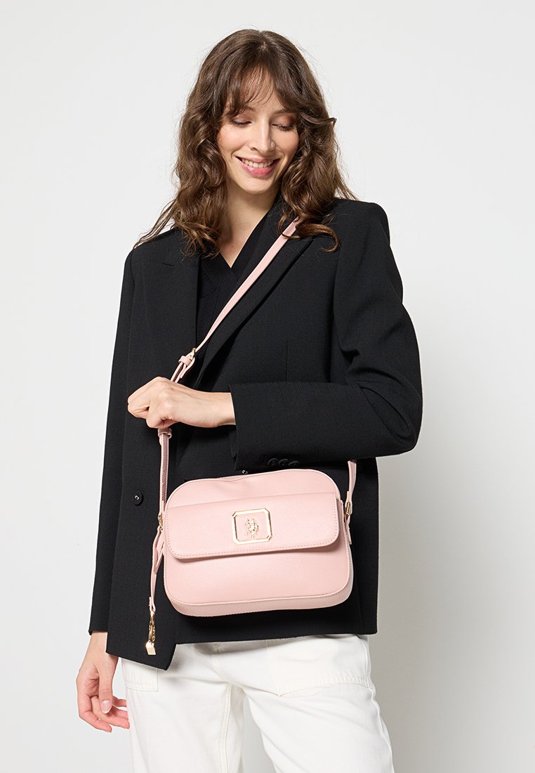 Borsa a tracolla rosa con una texture liscia, forma rettangolare, dettagli in metallo dorato e chiusura a patta. Cinturino regolabile per versatilità.