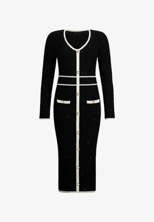 Black dress made of textured fabric with white trim. Features long sleeves, a V-neck, gold buttons, and pockets on the front.