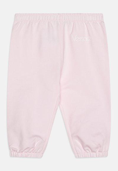 Gaiši rozā treniņbikses, izgatavotas no mīksta auduma, ar elastīgu jostu un savārstītiem piedurkņu galiem, tam pusē iešūta balta "Versace" emblēma.