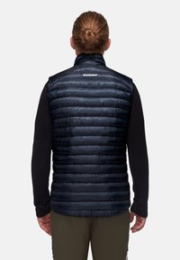 Isolierte marineblaue Weste mit horizontalem Steppdesign, hohem Kragen und Mammt-Logo auf dem Rücken, hergestellt aus glattem, wasserabweisendem Material.