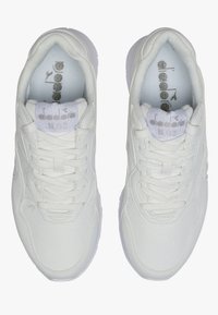 Sneaker bianco con tomaia in sintetico liscia, punta rotonda e lacci piatti. Presenta un colletto e una linguetta imbottiti, con un marchio discreto sulla linguetta.