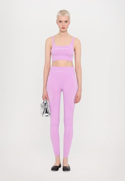 Lichtpaarse activewear set met een cropped top en high-waisted leggings. De stof is soepel met subtiele details aan de zijkanten.