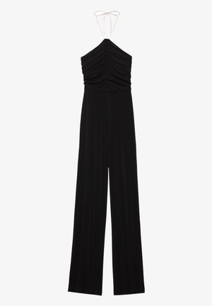 Mono negro sin mangas con cuello halter, cuerpo fruncido y pantalones de pierna ancha, atado en el cuello con una tira fina.