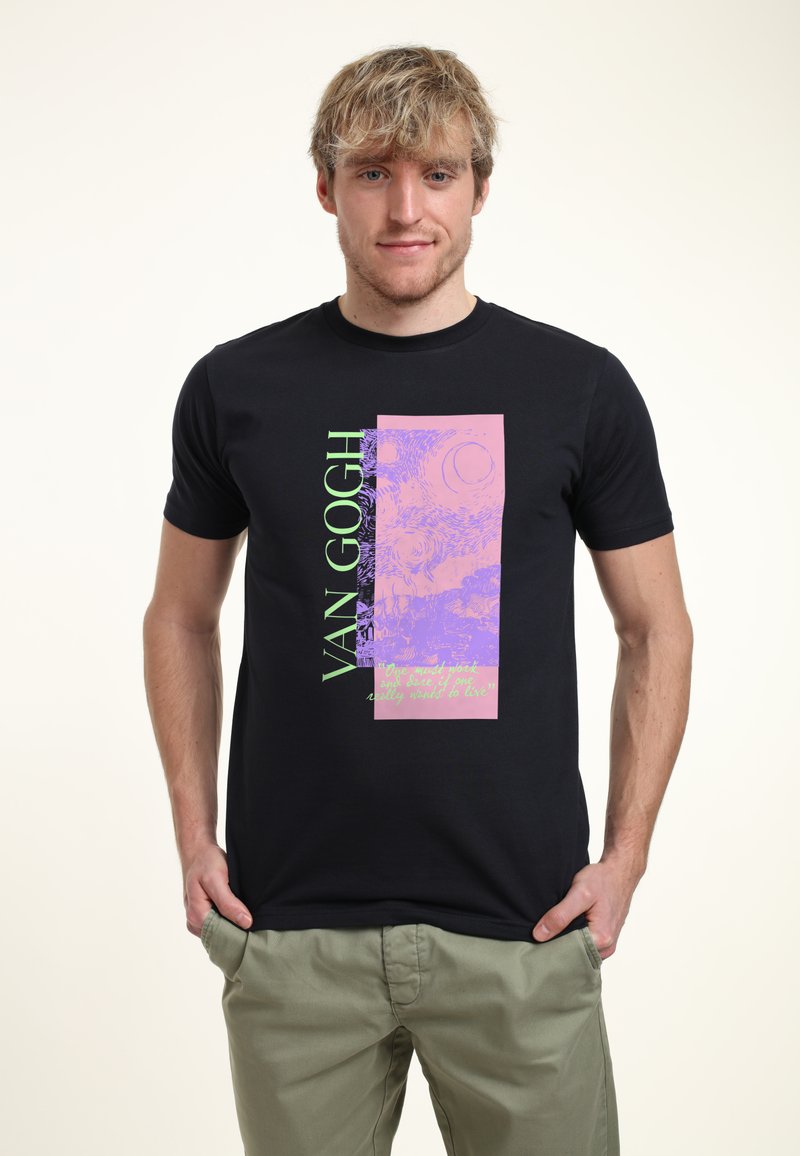 Camiseta negra con un diseño gráfico con acentos en púrpura y verde, que incluye el texto "VAN GOGH" y una cita. Cortas mangas, cuello redondo.