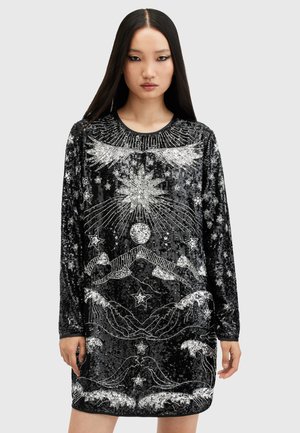 Black sequined dress with silver embroidered patterns, featuring stars, birds, and sun motifs. Long sleeves and rounded neckline.