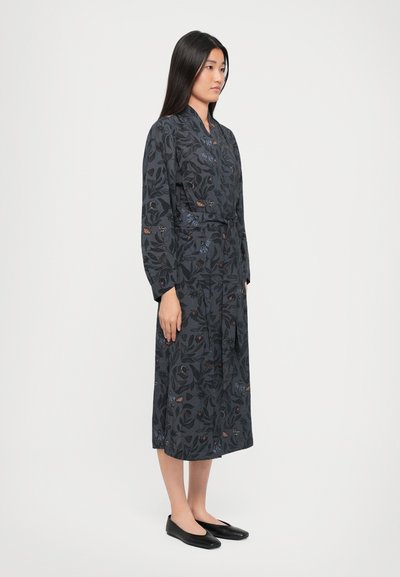 Long dark dress with floral patterns in blue, orange, and red. Made from fabric with a smooth texture. Includes a belted waist and buttons.