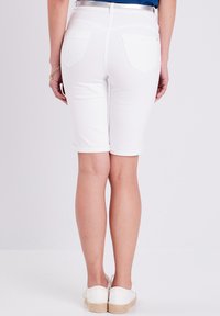Bermuda shorts in denim bianco, di lunghezza a metà coscia, con risvolti e due tasche posteriori. Tessuto liscio con una leggera elasticità.