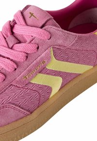 Baskets en suede rose avec des accents jaunes en synthétique, surface texturée, et lacets ronds. Pr�ésente une semelle en caoutchouc et un logo de marque en doré.