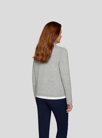 Grauer gestrickter Pullover mit Rundhalsausschnitt und geripptem Saum, kombiniert mit navyblauen Hosen. Glatte Textur, minimalistisches Design, keine sichtbaren Muster.