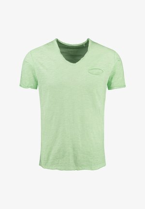 Jasnozielona koszulka typu V-neck z krótkim rękawem, o strukturalnym wykończeniu i małą kieszonką na piersi w kształcie owalu. Brzegi są lekko postrzępione.
