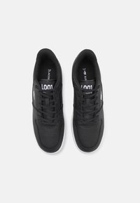 Schwarze Leder-Sneaker mit glatter Textur, ausgestattet mit Perforationen an der Zehe, flachen Schnürsenkeln und einer weißen Gummisohle. Akzentuiertes Logo und Modellnummer.