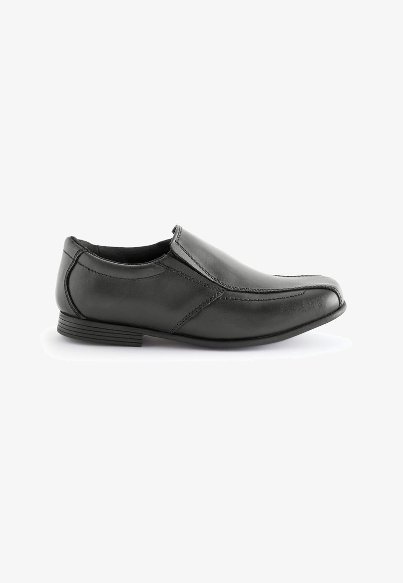 Black leather slip-on shoe with elastic side panels, featuring detailed stitching and a low stacked heel. Smooth texture and rounded toe.