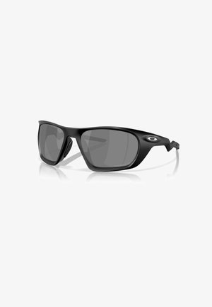 Lunettes de soleil en plastique noir avec verres gris. Elles présentent un design sportif, une forme enveloppante et des accents latéraux. Légères avec une finition mate.