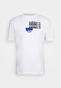 Bílý bavlněný tričko s modro-černým designem loga Adidas, stylizovaným textem a třemi listovými akcenty na levé straně.