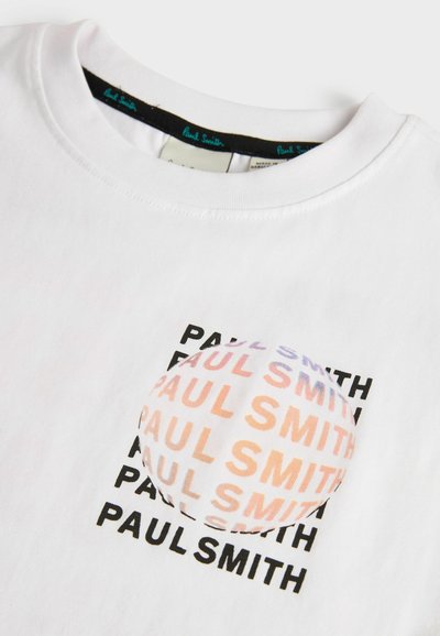 Balta medvilninė marškinėlių su trumpomis rankovėmis, kuriuose pakartotinai yra juodas tekstas "PAUL SMITH", ir apvalus audinio pleistras su spalvų gradientu švelniame atspalvyje.