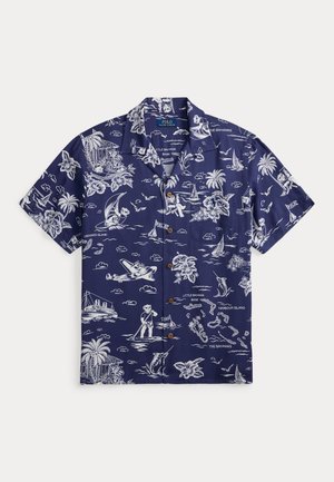 Σκούρο μπλε μπλουζάκι με κοντά μανίκια με κουμπιά, διακοσμημένο με λευκά τροπικά σχέδια που περιλαμβάνουν φοινικόδεντρα, λουλούδια, ιστιοπλοϊκά, αεροπλάνα και αρκούδες.