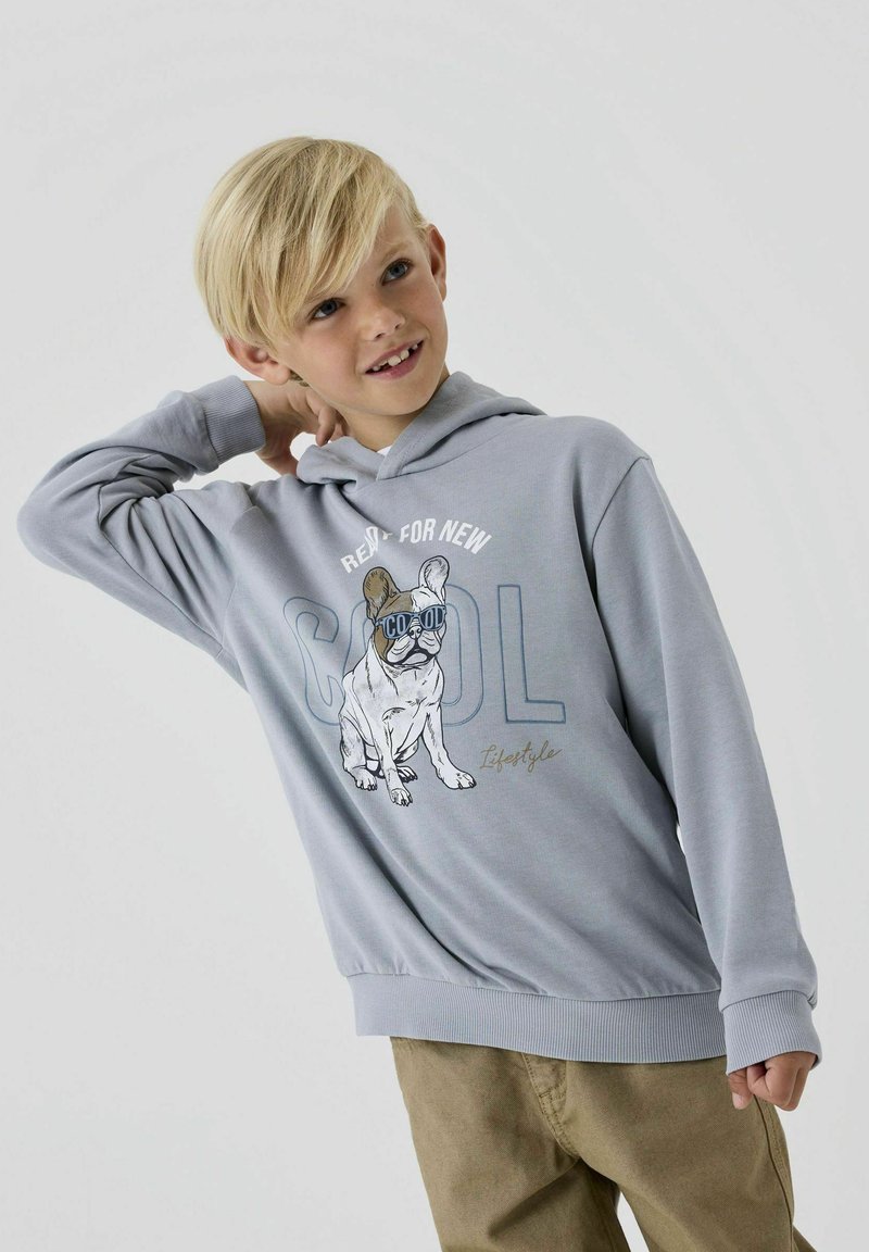 Harmaa huppari, jossa on ranskalaisen bulldogin grafiikka aurinkolaseilla, valkoiset tekstit "VALMIS UUDELLE VIILLE," sekä ribbattu hihansuujat ja helma.