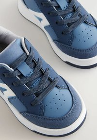 Niebieskie buty sportowe wykonane ze skóry i zamszu, charakteryzujące się teksturowaną powierzchnią, okrągłym czubkiem oraz szarymi sznurówkami. Zawierają białe i niebieskie akcenty.