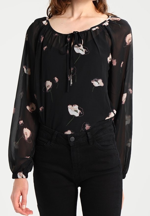 Schwarze, transparente Bluse mit Blumenmuster, langen Puffärmeln, Rundhalsausschnitt und Zugband. Kombiniert mit hoch taillierten schwarzen Jeans.
