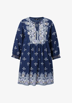 Marineblå kjole med hvide og lyse lilla blomster- og paisleymønstre, lange ærmer med elastiske manchetter og en rund halsudskæring med bindebånd foran.